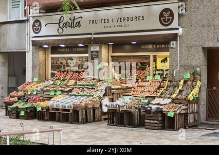 Viladecans. Espagne - 15 novembre 2024 : un stand de fruits animé débordant d'une sélection variée de fruits frais, à l'intérieur et à l'extérieur sur le côté Banque D'Images