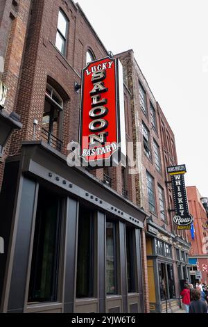 NASHVILLE, TN - 15 mars 2024 : panneaux pour le bar et le salon sur les bâtiments de Broadway dans le centre-ville de Nashville, Tennessee. Banque D'Images