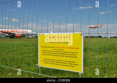 Signe de zone de sécurité côté piste sur la clôture périphérique de l'aéroport London Southend Essex, avec des avions de ligne easyJet citant l'ordre de navigation aérienne 2005 Banque D'Images