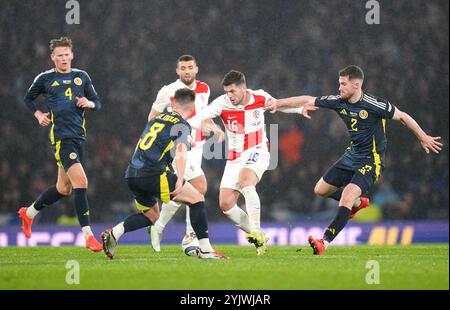 Le croate Martin Baturina (au centre) se bat pour le ballon contre l'écossais Billy Gilmour (deuxième à gauche) et Anthony Ralston (à droite) lors du match du Groupe A1 de l'UEFA Nations League à Hampden Park, Glasgow. Date de la photo : vendredi 15 novembre 2024. Banque D'Images