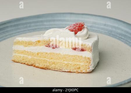 Un petit shortcake japonais à la fraise sur une grande assiette élégante sur une table blanche. Banque D'Images