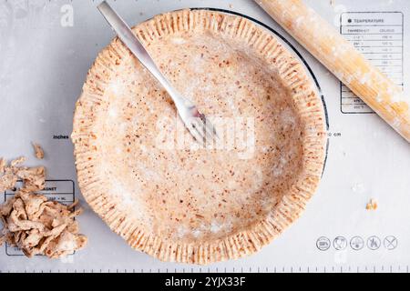 Pâte à croûte de tarte à biscuits au pécan serti : directement au-dessus d'une croûte de tarte maison non cuite faite avec des noix et de la cannelle Banque D'Images