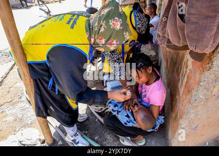 Nairobi, Kenya. 4 octobre 2024. Une jeune femme vue tenant un bébé alors que des agents de santé effectuent une vaccination communautaire orale contre la poliomyélite. La polio est un virus qui peut causer la paralysie et qui est facilement évitable grâce au vaccin contre la polio. Le virus se transmet facilement par voie fécale-orale, eau contaminée, aliments ou contact corporel avec une personne infectée, y compris des gouttelettes respiratoires qui pourraient mener à une paralysie mortelle si aucun diagnostic médical rapide n'est pris. Il affecte principalement les enfants de moins de 5 ans, mais aussi toute personne d'un âge différent, qui n'est pas vaccinée peut contacter les maladies. Le Kenya pédiatrique Banque D'Images