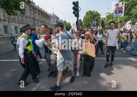 Londres, Royaume-Uni. 21 juin 2017. Alors que la marche atteignait Downing St, un petit groupe se dirigeait vers la ligne de police devant les portes. D'autres manifestants les ont retirés et certains des organisateurs de la marche ont formé une ligne entre les manifestants et la police, exhortant les manifestants à en déplacer une. Ils ont ensuite organisé un court rassemblement au milieu de Whitehall avant qu'un consensus ne décide de passer à Parliament Square, où la marche s'est terminée au milieu de la route. Il y a eu plus de discours et de scandales là-bas avec les manifestants ignorant les demandes de la police de dégager la route. Après environ 20 minutes, la plupart des manifestants ont déplacé un Banque D'Images