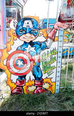 Newcastle UK : 26 juin 2024 : Newcastle Hoppings Funfair. Panneau de mesure de hauteur coloré représentant un personnage de super-héros lors d'un carnaval Banque D'Images