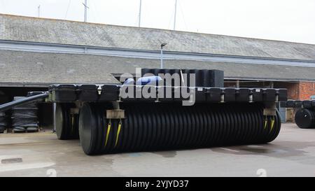 Royal Clarence Yard, Weevil Lane, Gosport, Hampshire, Angleterre. 11 novembre 2024. La zone est progressivement rénovée avec un mélange d'entreprises et de logements privés et sociaux. Cette photo montre une vue grand angle d'une plate-forme flottante sur terre ferme à côté d'une cour de bateaux. Banque D'Images