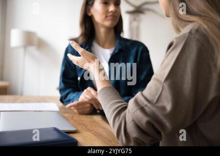 Gros plan sur deux femmes menant un dialogue assis à la table du lieu de travail Banque D'Images