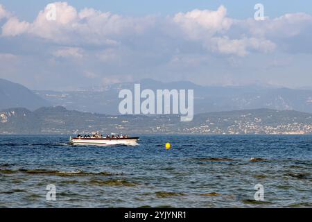 Sirmione, Italie - Sep 21st, 2024 : un bateau d'excursion transportant des touristes croisières à travers les eaux calmes du lac de Garde Banque D'Images