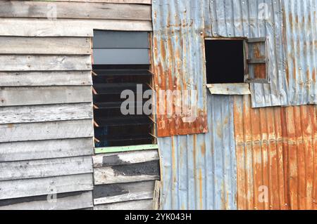 Vieux Mur de zinc au reste de la maison en feu Banque D'Images