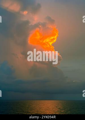 La foudre et le coucher du soleil illuminent un orage au-dessus de la mer des Caraïbes donnant une scène dramatique Banque D'Images