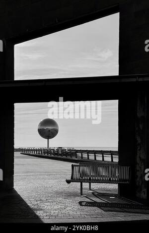 Abri avec banc sur South Promenade encadrant une sculpture géante de boule miroir, Blackpool UK Banque D'Images