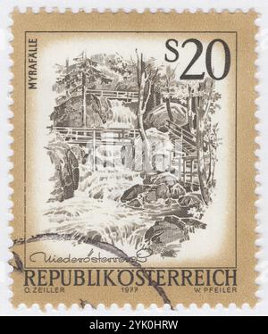 AUTRICHE - 1977-12-07 : un timbre-poste de 20 shillings olive-bister et olive représentant les cascades de Myra. Les chutes de Myra sont situées dans un ravin de la municipalité de Muggendorf dans l'État fédéral autrichien de basse-Autriche. Le ravin a été coupé par le Myrabach, un petit affluent du Piesting. Le Myra, comme le ruisseau est également connu, s'élève au pied de l'Unterberg à partir du Myralucke, une source imprégnée de légende, qui est alimentée par un lac souterrain. Bien que la Myra ne soit longue que de quelques kilomètres, elle alimentait un grand nombre de moulins et de scieries dans la vallée de la Myra Banque D'Images