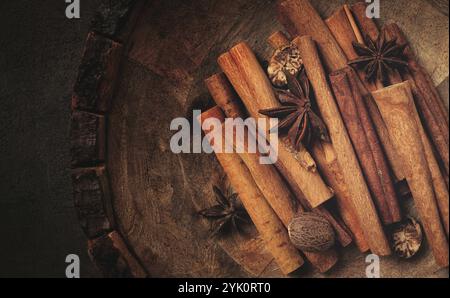 Bâtonnets de cannelle, avec noix de muscade et étoile d'anis, dans une assiette en bois, vue de dessus, pas de gens Banque D'Images