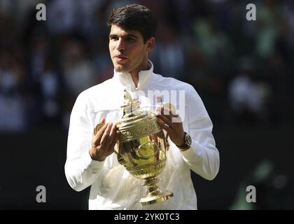 Le joueur de tennis espagnol Carlos Alcaraz (ESP) détient le trophée du championnat après avoir remporté la finale masculine des Championnats de Wimbledon 2024 Banque D'Images