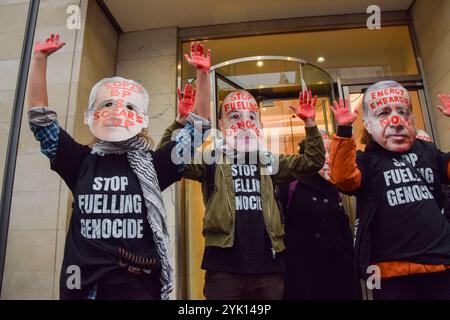 Londres, Royaume-Uni. 16 novembre 2024. Des manifestants portant les masques du président de la COP29 Mukhtar Babayev, du président de l'Azerbaïdjan Ilham Aliyev et du président turc Recep Erdogan se tiennent les mains couvertes de faux sang devant les bureaux de SOCAR sur le Strand. Des centaines de manifestants ont défilé dans le centre de Londres pour exiger la justice climatique et la fin des combustibles fossiles, et en solidarité avec la Palestine, alors que la COP29 se poursuit en Azerbaïdjan. Crédit : Vuk Valcic/Alamy Live News Banque D'Images