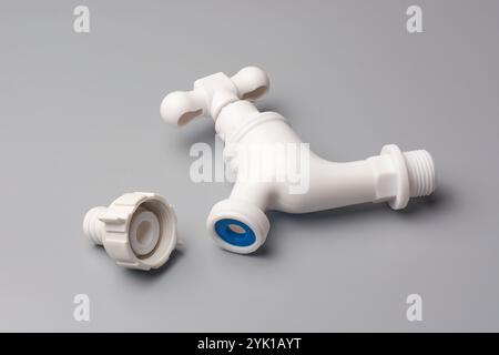 robinet en plastique blanc avec poignée transversale et connecteur fileté fond gris isolé, utilisé dans les machines à laver ou les éviers Banque D'Images