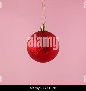 Ornements de boule de Noël rouge sur fond rose. idée de concept minimale. Banque D'Images