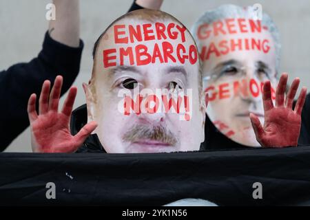 Londres, Royaume-Uni. 16 novembre 2024. Un activiste porte un masque représentant le président azerbaïdjanais Ilham Aliyev devant le bureau londonien de la Société pétrolière d'État de la République d'Azerbaïdjan (SOCAR) alors qu'une coalition de plus de soixante groupes de campagne pour le climat et des partisans palestiniens défilent dans le centre de Londres pour exiger que le gouvernement mette fin à notre dépendance aux combustibles fossiles, rembourse le financement climatique et cesse de soutenir la guerre d'Israël contre Gaza. L'Azerbaïdjan, qui accueille actuellement les négociations sur le climat de la COP29, fournit environ 30 % du pétrole israélien via la Turquie. Crédit : Ron Fassbender/Alamy Live News Banque D'Images