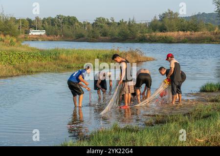 Vietnam, île de Phu Quoc, 12 février 2024, Un groupe d'habitants dans une petite rivière pêchant avec un filet Banque D'Images