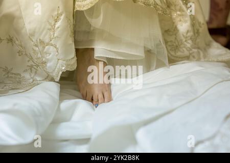 Élégante mariée entrant dans sa robe de mariée le matin du jour du mariage Banque D'Images