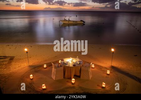 Table et chaises pour un dîner romantique aux chandelles sur la plage du trou aux Biches Beachcomber Golf Resort Banque D'Images