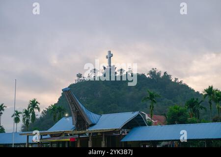 Une grande croix sur une montagne avec une maison traditionnelle Toraja et les mots Toraja Nord écrits dessus Banque D'Images