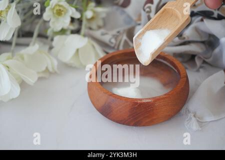 Verser du bicarbonate de soude dans un bol d'eau Banque D'Images