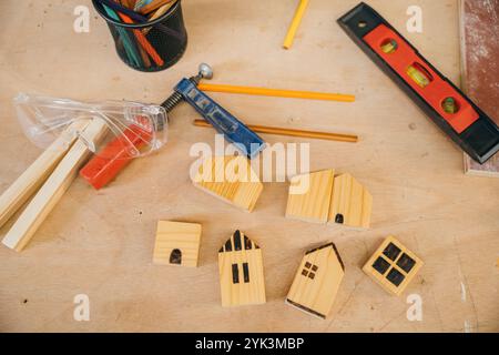 Maisons en bois, crayons et outils sur un établi. Parfait pour la construction de maison, les projets de bricolage, et Banque D'Images