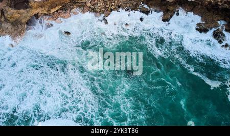 Vue aérienne des vagues de l'océan s'écrasant sur les rochers à Nazaré, Portugal Banque D'Images