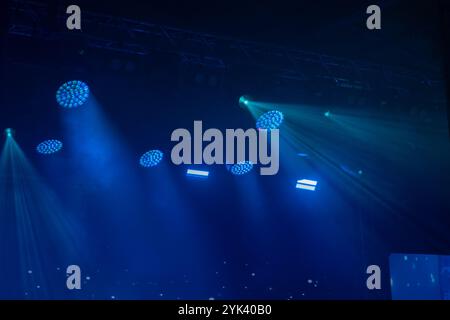 Lumières bleues projetant des faisceaux sur scène créant une atmosphère mystérieuse. Parfait pour les concerts, le théâtre et les événements. Capte l'énergie et l'ambiance. Banque D'Images