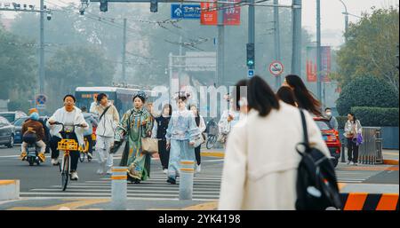 Pékin, Chine. Jolies filles en robes chinoises traditionnelles marchent le long de la rue à Pékin. Filles dans les robes chinoises nationales Cross Road. Piétons Banque D'Images