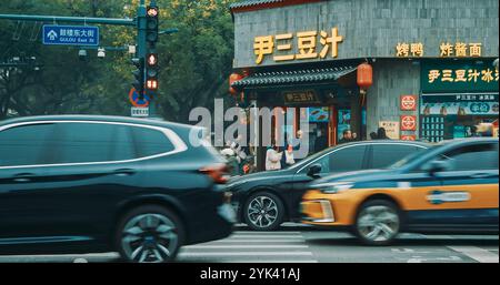 Pékin, Chine. Trafic sur Gulou East Street à Pékin. Beaucoup de voitures électriques sur la route. Voitures se déplaçant sur la rue dans la soirée. Restaurant Michelin on Banque D'Images