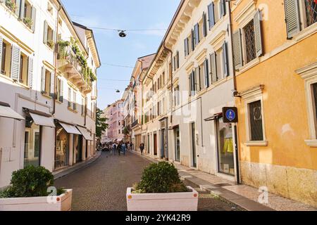 Vérone, Italie - 12 octobre 2021 : étroite rue pavée ensoleillée à Vérone Banque D'Images