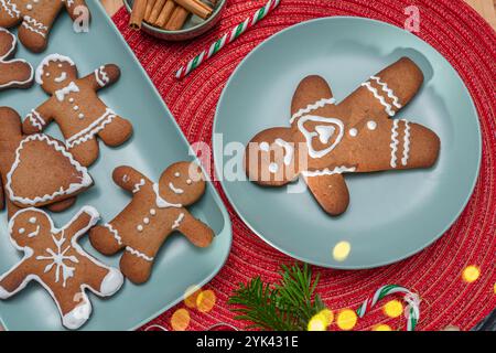 Hommes en pain d'épices, biscuits de noël décorés de glaçage royal sur plaque bleue, vue de dessus. Banque D'Images