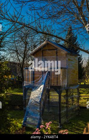 Une maison en bois dans les arbres pour les enfants protégé contre la neige et la pluie d'hiver avec du papier d'aluminium Banque D'Images