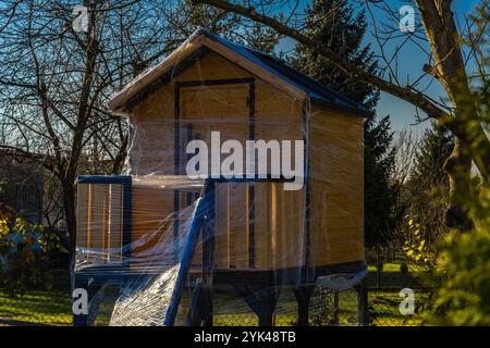 Une maison en bois dans les arbres pour les enfants protégé contre la neige et la pluie d'hiver avec du papier d'aluminium Banque D'Images