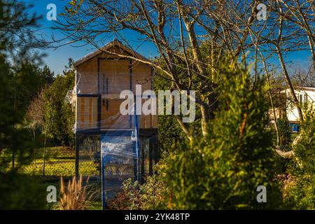 Une maison en bois dans les arbres pour les enfants protégé contre la neige et la pluie d'hiver avec du papier d'aluminium Banque D'Images