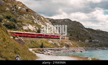 Moritz, Suisse 11 août 2021. Moment pittoresque sur la ligne Bernina : un train rouge traverse le paysage alpin, reflétant l'aventure et le natu Banque D'Images