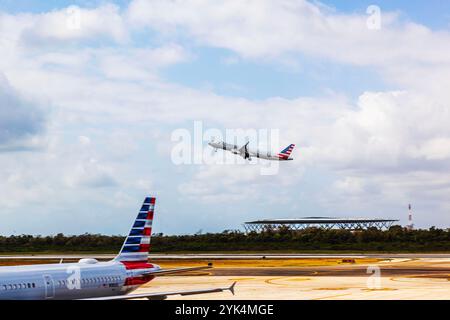 Avion d'American Airlines décollant de l'aéroport de Cancun, Mexique, sous un ciel partiellement nuageux. Cancun. Mexique. Banque D'Images