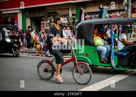 Un homme philippin fait son chemin le long d'une rue de marché animée dans le quartier China Town de Manille City, aux Philippines. Banque D'Images