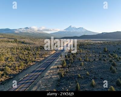 Vue aérienne du mont Shasta depuis le dessus de la route 97, Californie, au coucher du soleil, en automne, avec de la neige neuve, teintes orange, ciel clair, forêt au premier plan. Banque D'Images