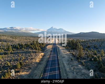 Vue aérienne du mont Shasta depuis le dessus de la route 97, Californie, au coucher du soleil, en automne, avec de la neige neuve, teintes orange, ciel clair, forêt au premier plan. Banque D'Images