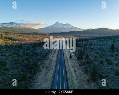 Vue aérienne du mont Shasta depuis le dessus de la route 97, Californie, au coucher du soleil, en automne, avec de la neige neuve, teintes orange, ciel clair, forêt au premier plan. Banque D'Images