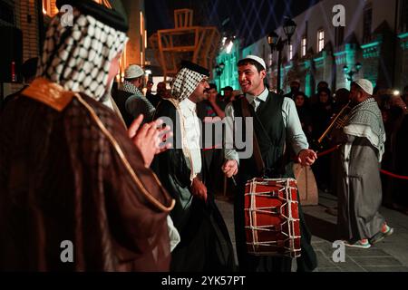 Bagdad, Irak. 13 novembre 2024. Les gens portant des costumes folkloriques dansent pendant le festival de la fête de Bagdad sur la rue Al-Saray. Bagdad Day Festival célèbre l'histoire et la civilisation de Bagdad. L'événement 'Bagdad Simulation', l'un des segments du festival qui vise à faire revivre l'atmosphère de la ville dans une période allant de 1924 à 2024 en réincarnant des personnages traditionnels et des rôles essentiels qui ont joué un rôle central dans la vie quotidienne à Bagdad. (Crédit image : © Ismael Adnan/SOPA images via ZUMA Press Wire) USAGE ÉDITORIAL SEULEMENT! Non destiné à UN USAGE commercial ! Banque D'Images