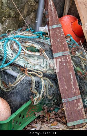 gros plan d'équipements maritimes ou nautiques, y compris une vieille rame en bois, des cordes et des bouées de pêche ou des flotteurs en tas ou en tas sur un quai. Banque D'Images