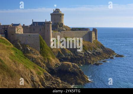 Un château médiéval perché sur des falaises surplombant la mer bleue sous un ciel clair, Fort la Slat, Château de la Roche Goyon, Cap Fréhel, côtes d Armor, Br Banque D'Images