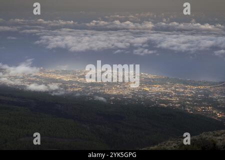 Vue nocturne depuis le parc national du Teide, Parque Nacional del Teide, jusqu'à Orotava illuminée, Puerto de la Cruz et nuages de vent commercial au-dessus de l'Atlan Banque D'Images