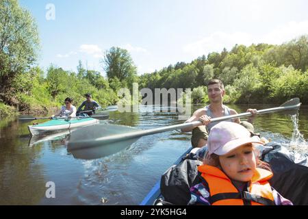 Excursion en kayak en famille. Père et fille, couple de personnes âgées et bateau à rames seniora sur la rivière, une randonnée dans l'eau, une aventure d'été. Écologique Banque D'Images