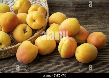 Abricots juteux mûr dans un panier sur un fond de bois Banque D'Images