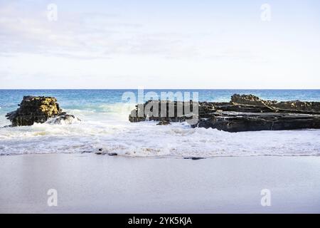 Vagues de mer frappant des rochers à la plage Banque D'Images